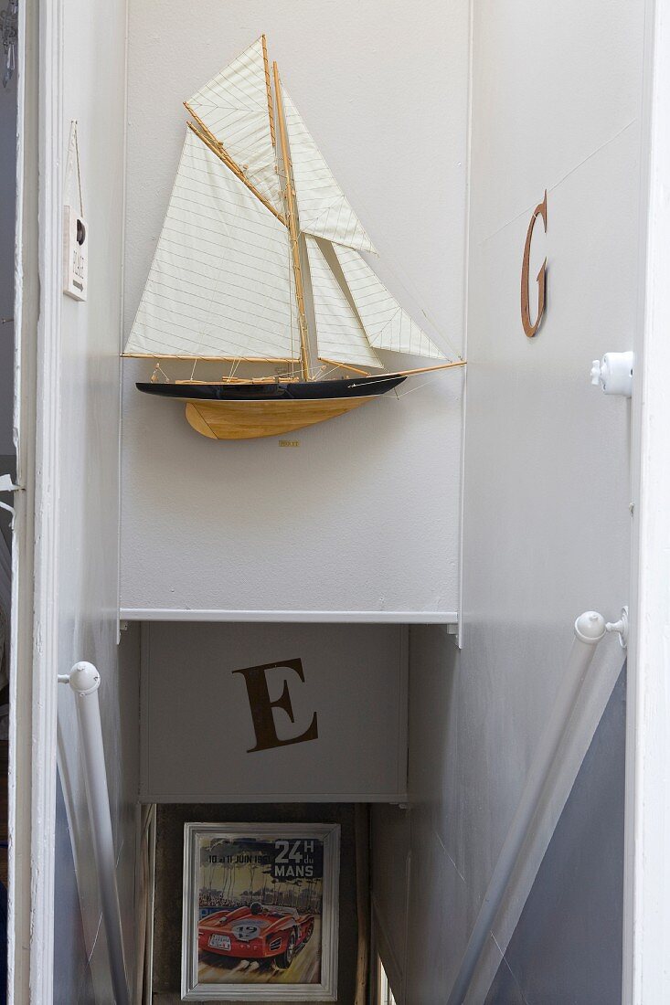 Model sailing boat above head of staircase in narrow stairwell