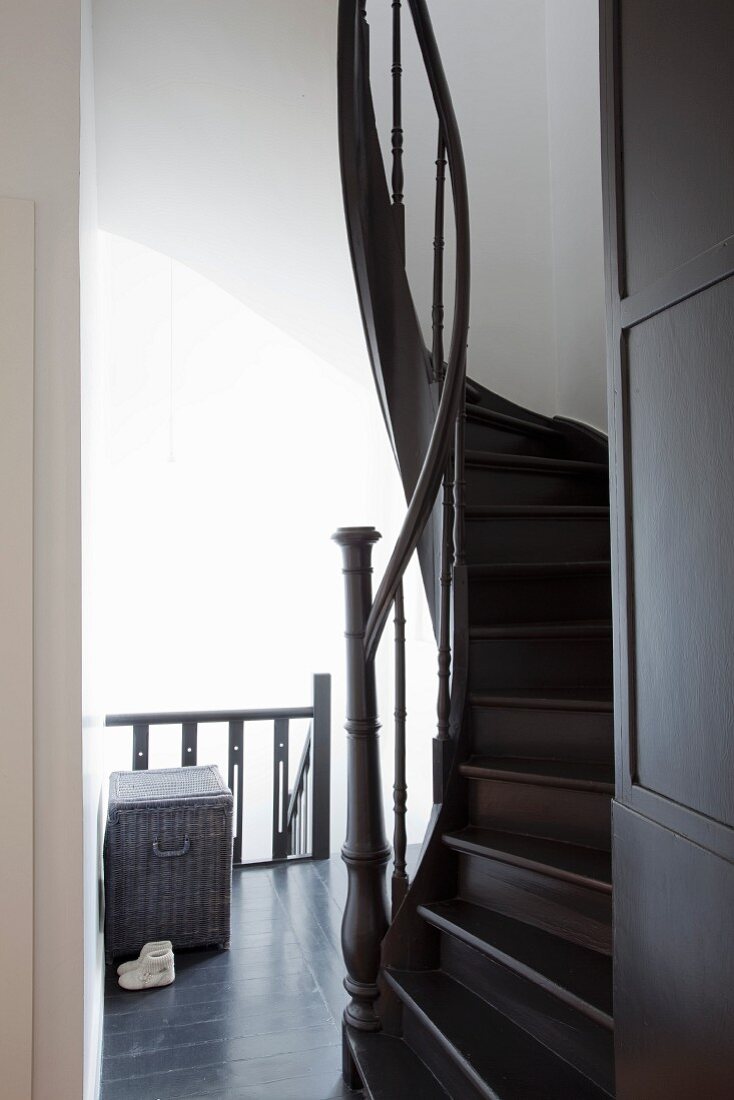 Winding wooden staircase painted a dark shade