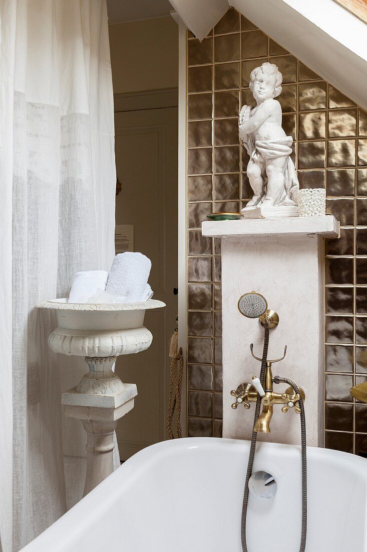 Badewanne mit nostalgischer Armatur und weißer Putte auf Vormauerung, renoviertes Ambiente