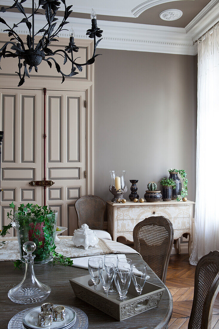 Stemware and glass carafe on tray on table in grand dining room