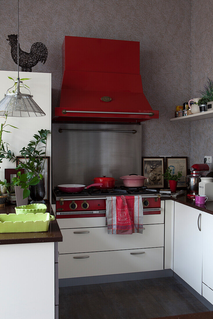 Large gas cooker under read-painted extractor hood