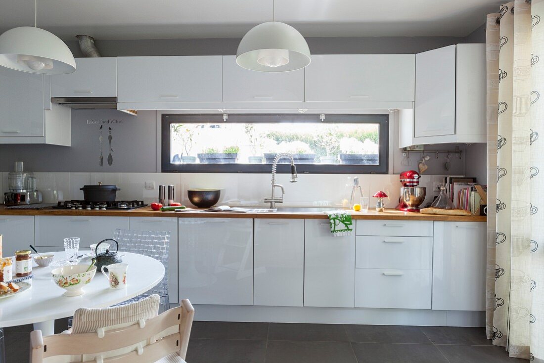 weiße Einbauküche mit Fensterband