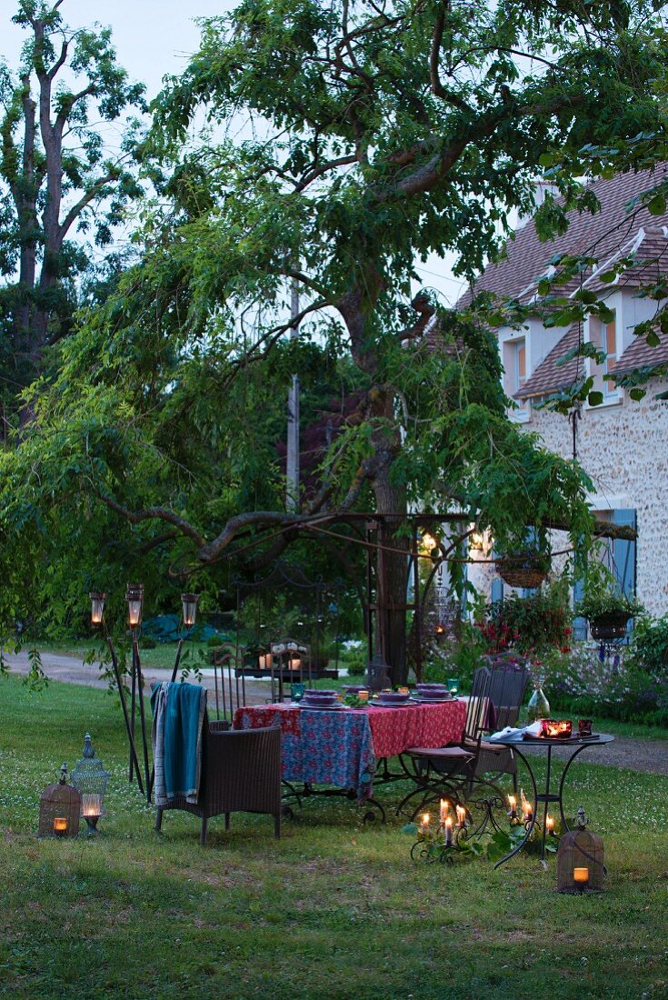 Romantic candlelit atmosphere around set garden table in rustic setting