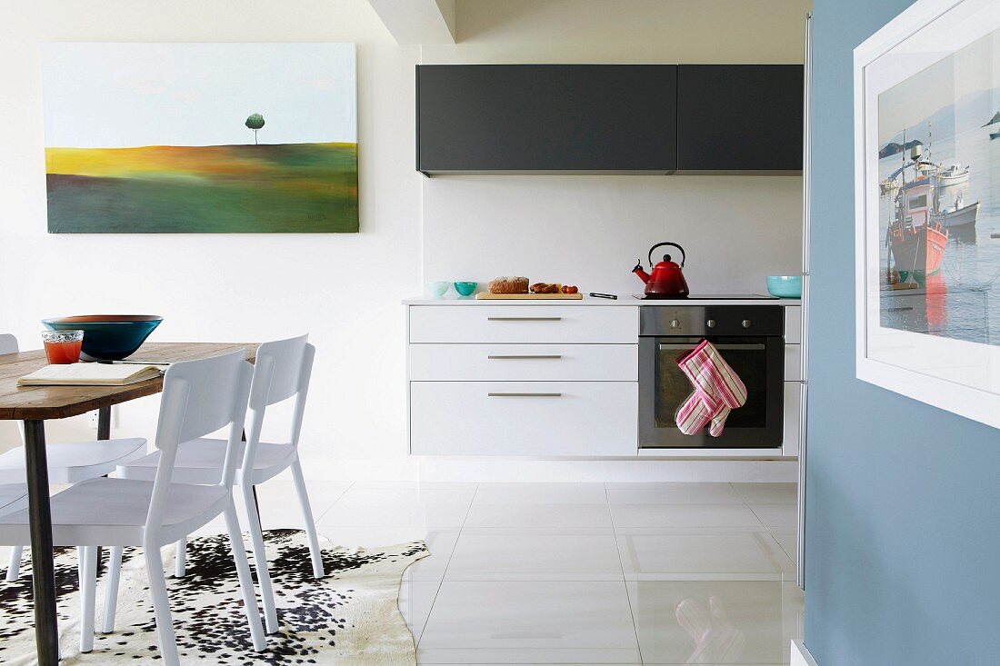 Bright, open-plan kitchen with floating base cabinets and dining area in foreground