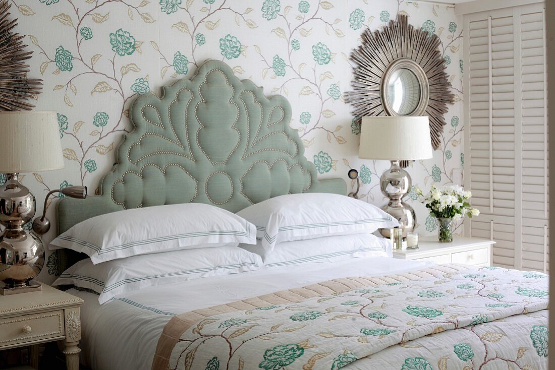 Bed with ornate upholstered headboard in elegant bedroom
