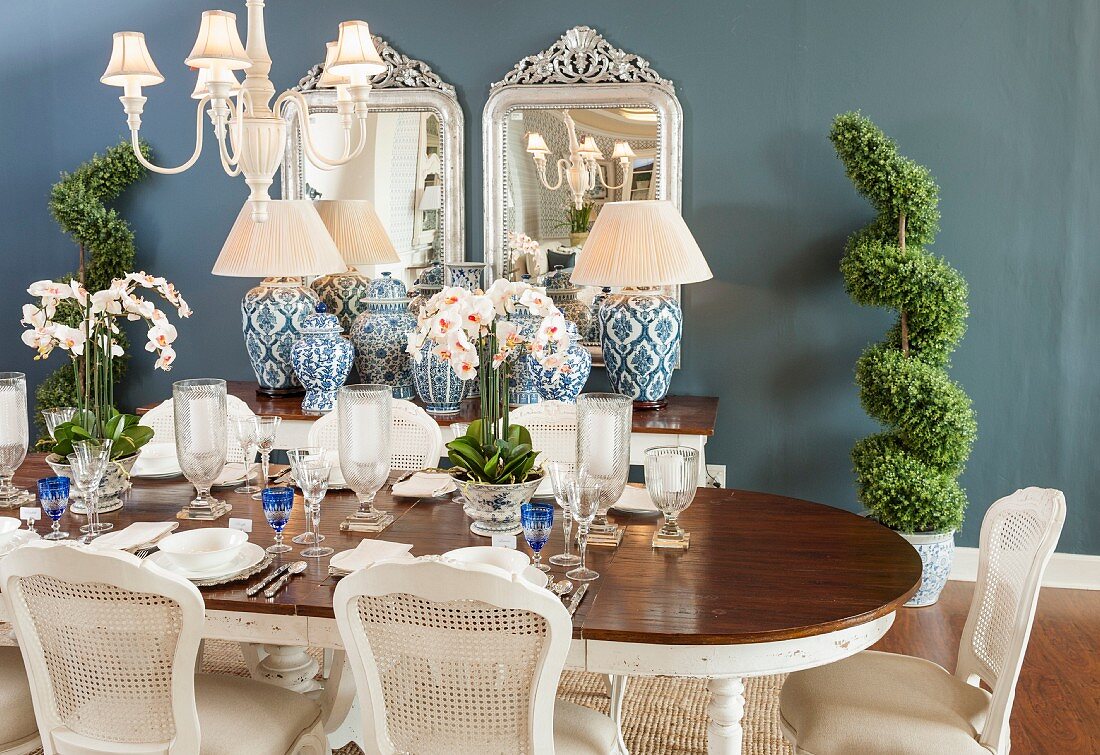 Elegantly set dining table, cane-back chairs and antique accessories