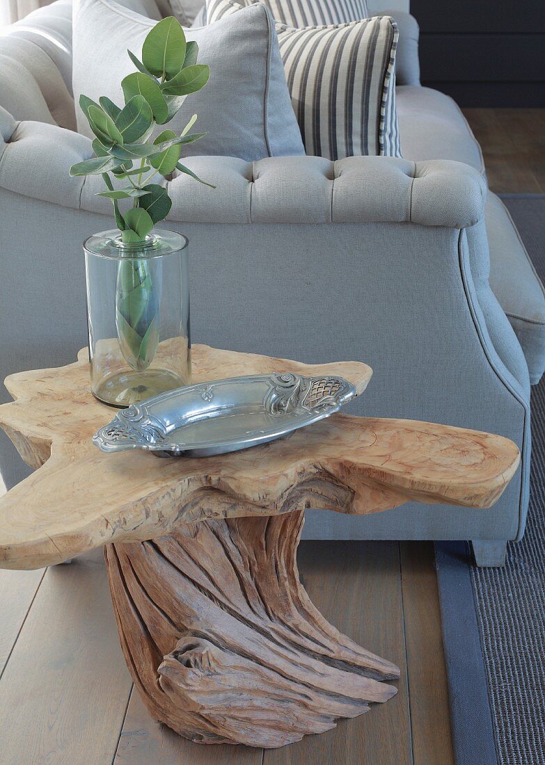 Organically shaped wooden side table next to elegant sofa