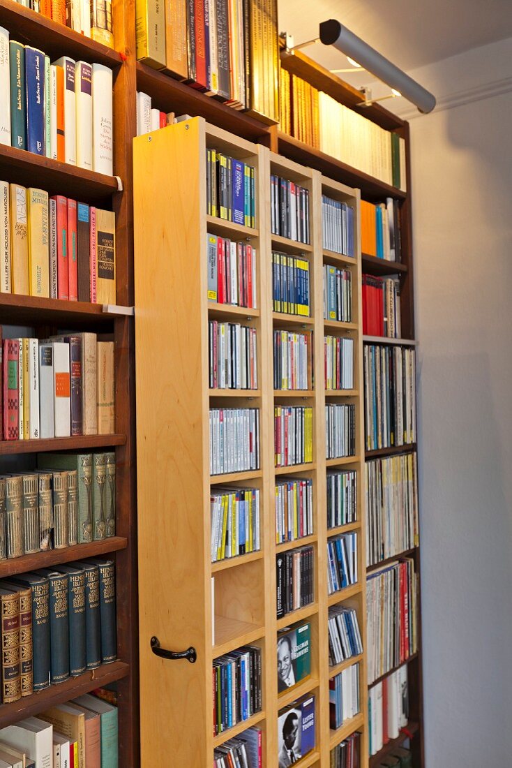 Bücherwand mit fahrbarem Regalelement, oberhalb Beleuchtung