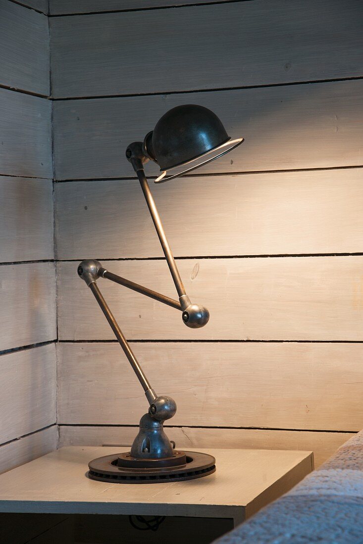 Gelenklampe (Loft Zick-Zack) auf Nachttisch in holzverschalter Zimmerecke
