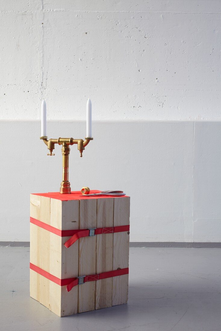 DIY stool made from bound wooden slats and candelabra made from brass pipes