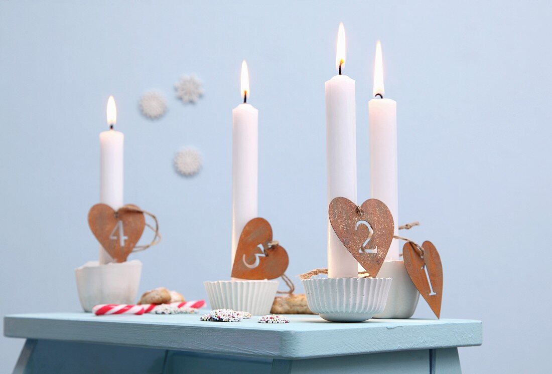 Advent candle holders for single candles made from silicone muffin cases, plaster and numbers on heart-shaped pendants