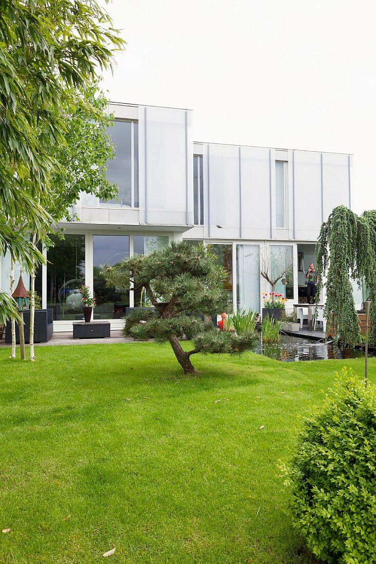 Blick auf moderne Wohnhaus mit gepflegtem Garten und Gartenteich