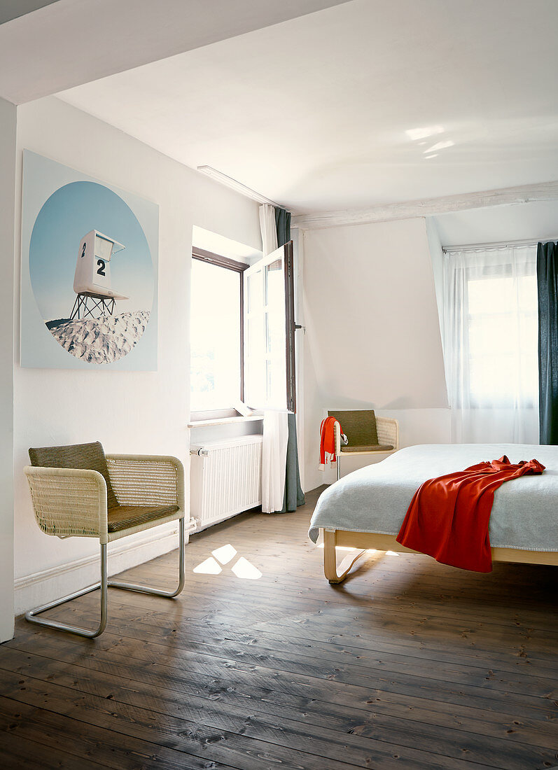 Freischwinger mit hellem Rattan Geflecht in schlichtem Schlafzimmer, rustikaler Dielenboden