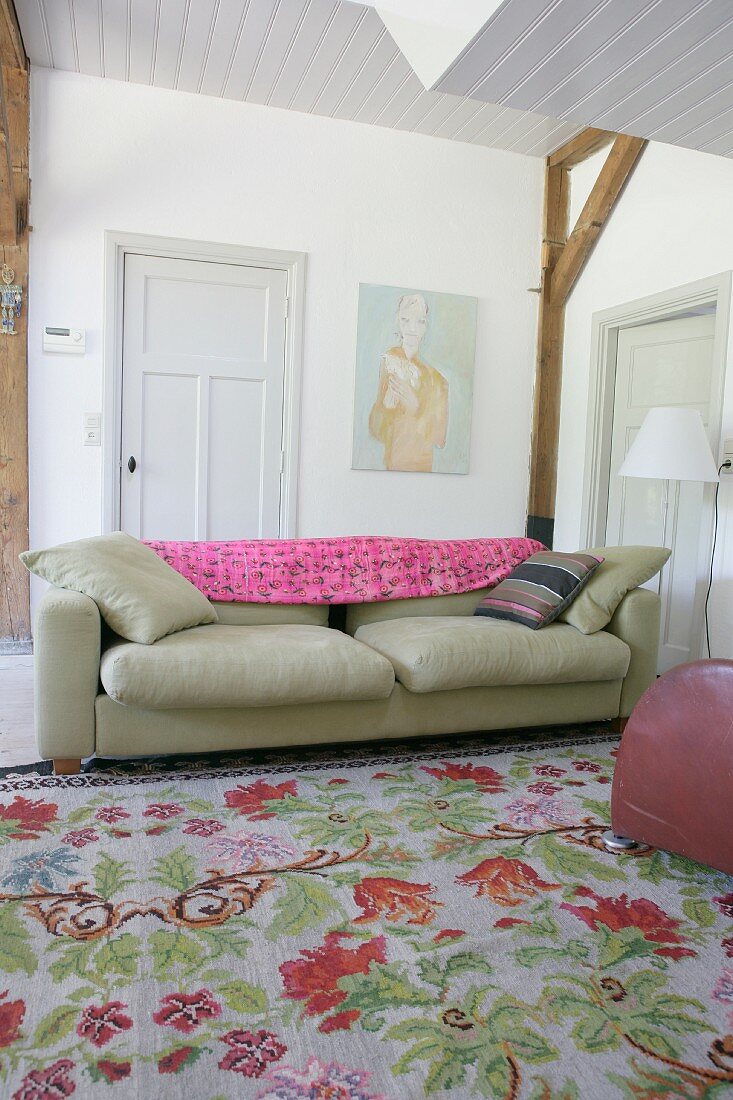 Vintage-style floral rug in front of sofa in rustic interior