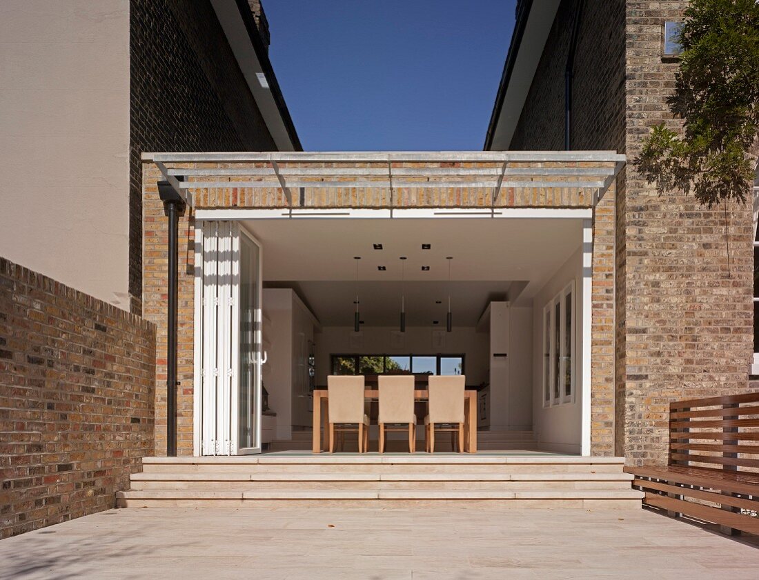 Extension between two houses; view of dining area through open folding doors
