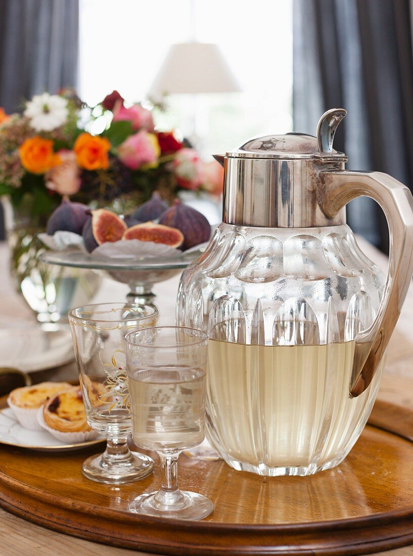 Vintage-style water jug and elegant stemware on tray