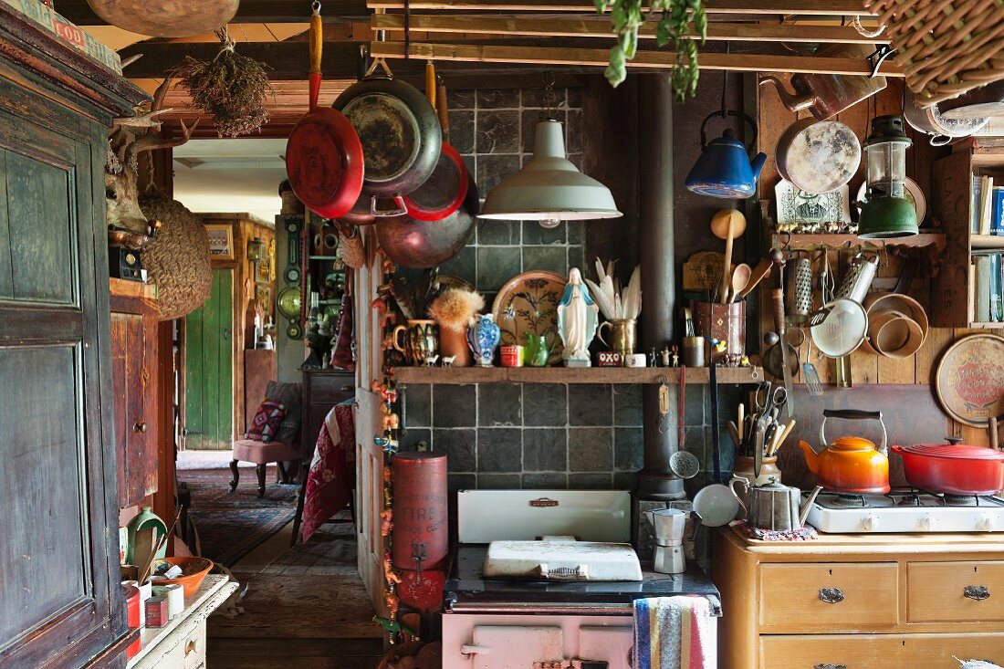 Vintage-Küche mit aufgehängtem Kochgeschirr und vollgestellten Regalen