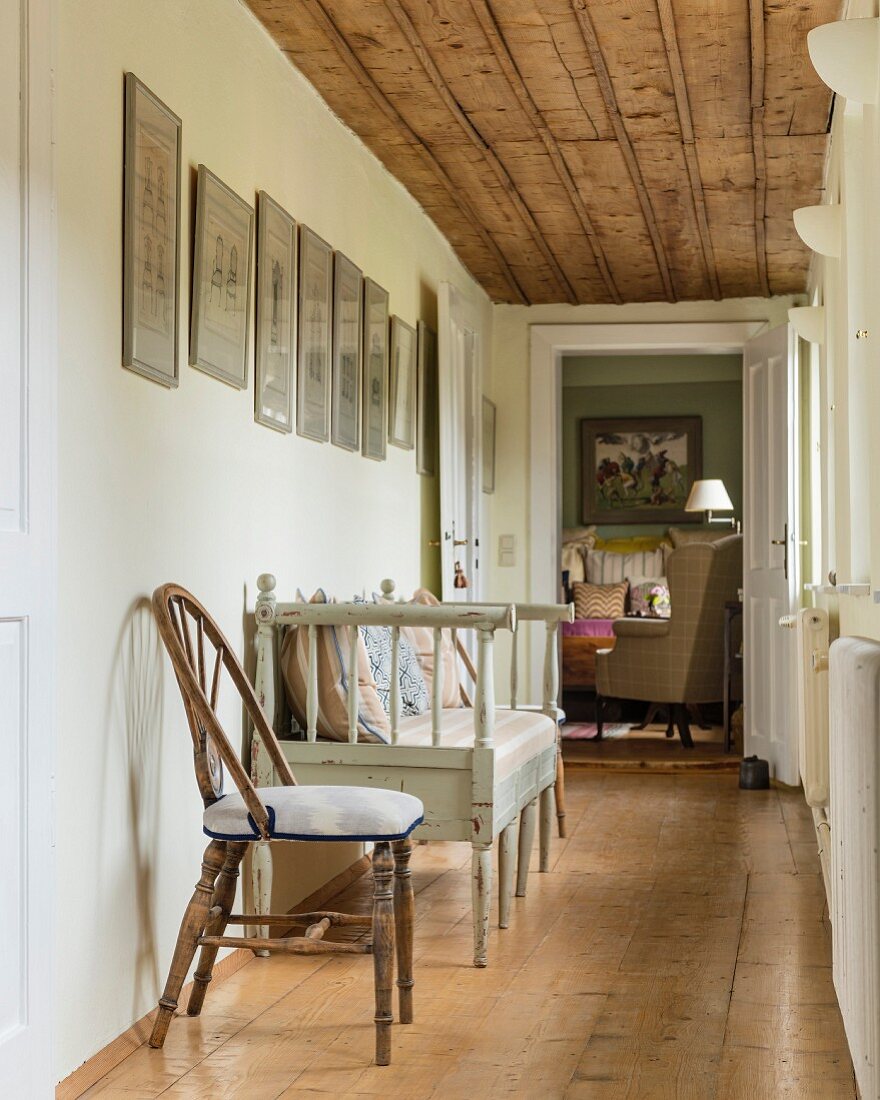 Chair and Scandinavian bench in narrow hallway with rustic wooden ceiling