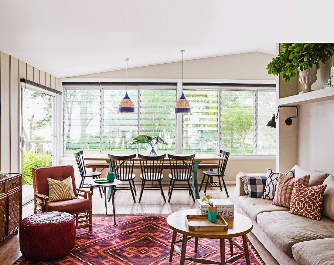 Living room in a beach house with a dining table by the window and a seating area with a pattern mix carpet