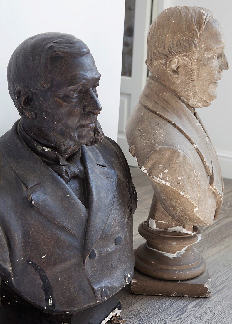 Two plaster busts of men painted dark and light