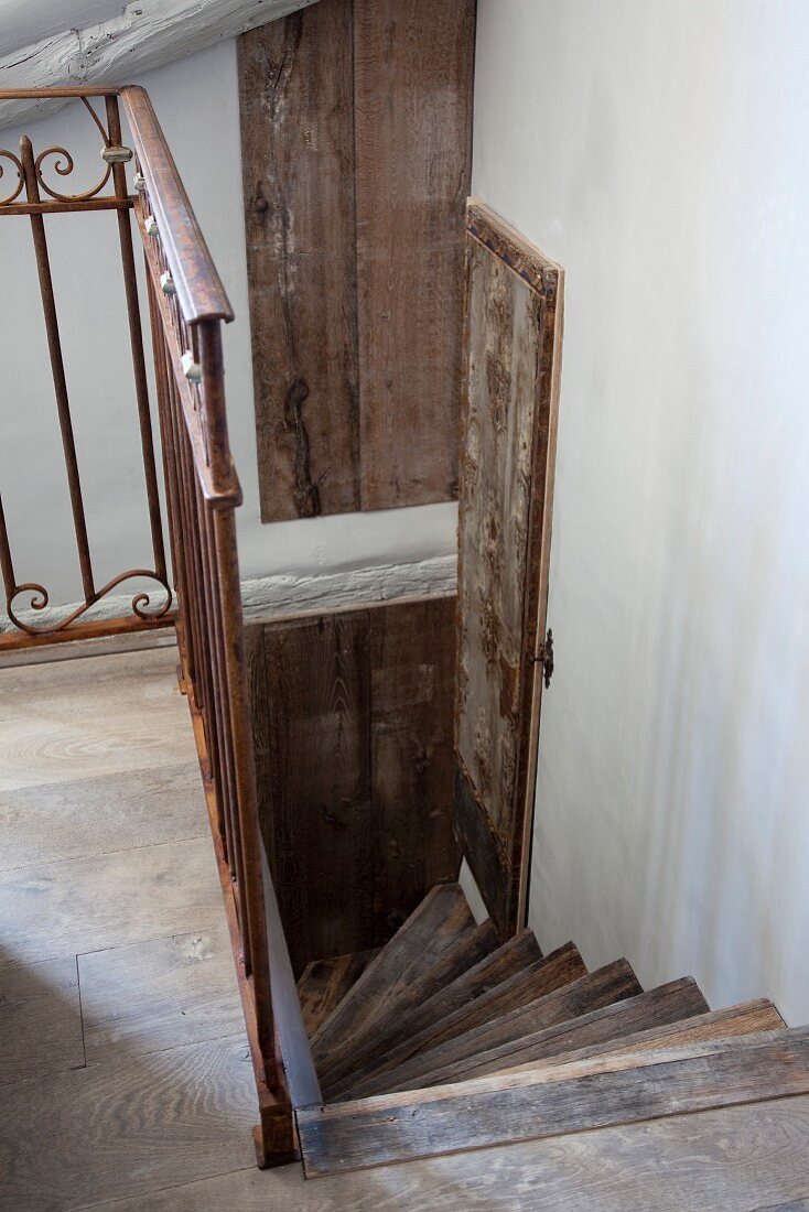 Blick auf gewendelte Holztreppe in rustikalem Ambiente