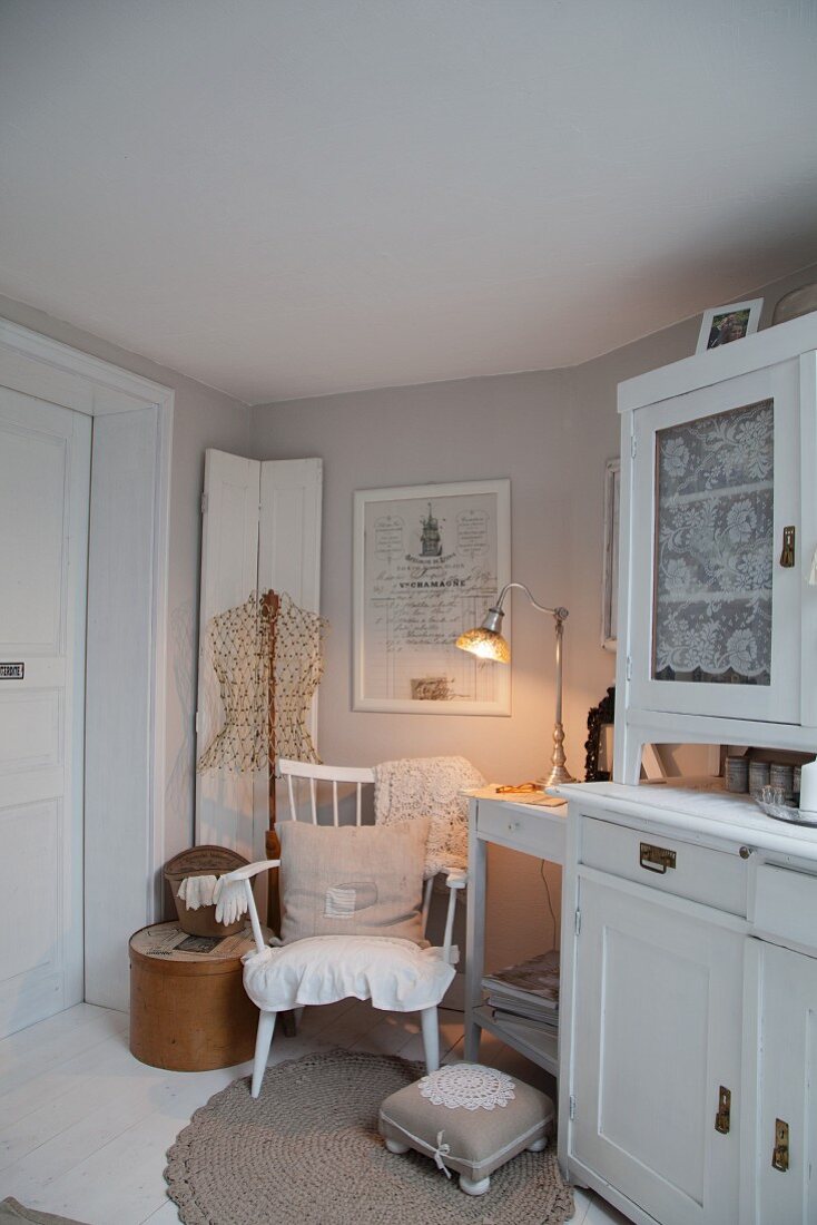 White dresser next to cosy seating area with romantic ambiance