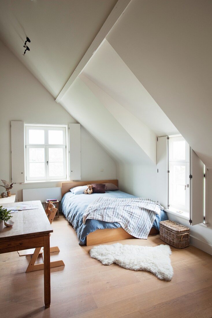 Interior shutters on windows in child's attic bedroom with sloping ceiling