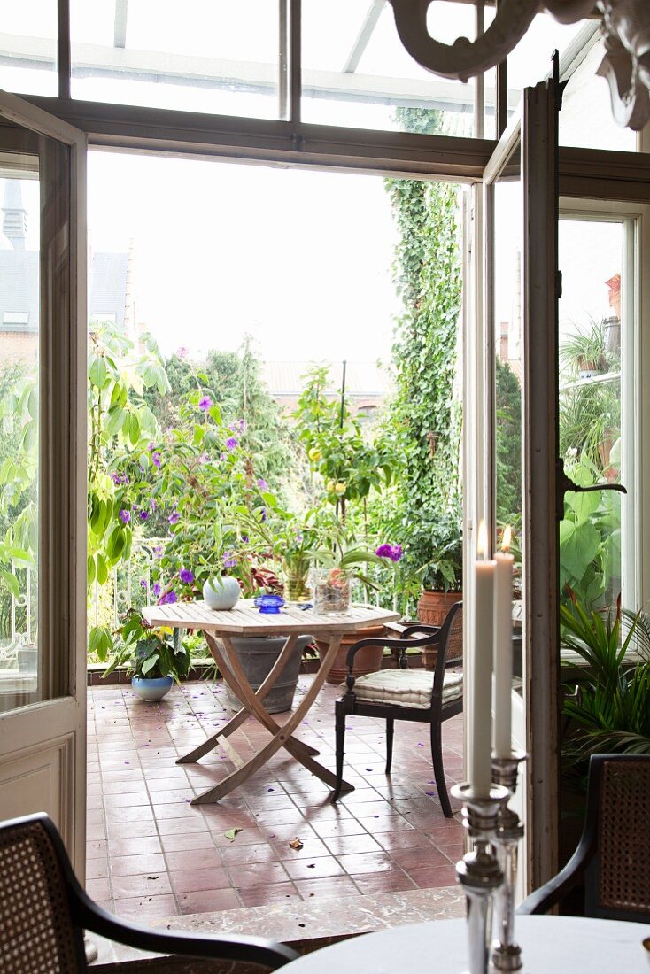 Blick durch offene Tür auf Terrasse mit Sitzplatz