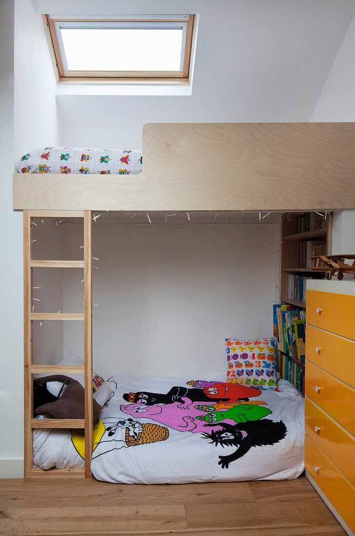 Child's attic bedroom - custom loft bed with ladder under skylight, futon sofa and chest of drawers with yellow front