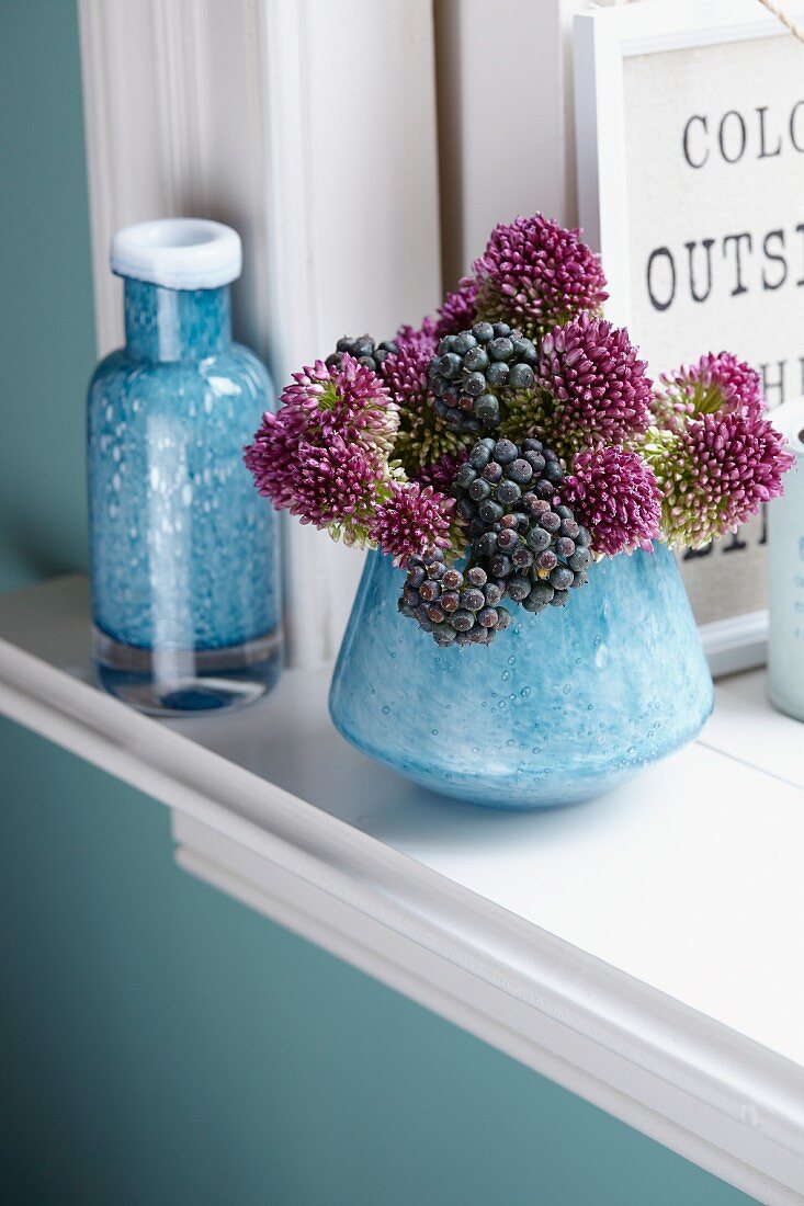 Alliumblüten & Efeubeeren als herbstliches Sträusschen in Vase auf Fensterbank