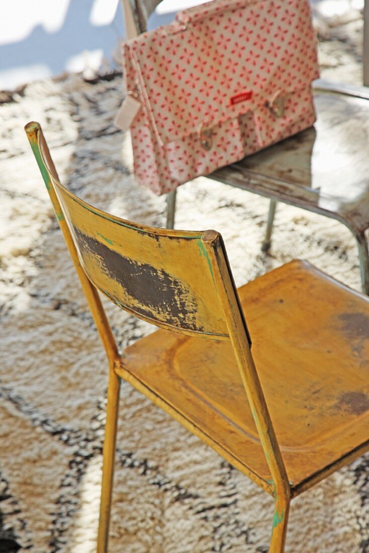 Vintage Metallstühle verschiedenfarbig lackiert, auf berberartigem Teppich