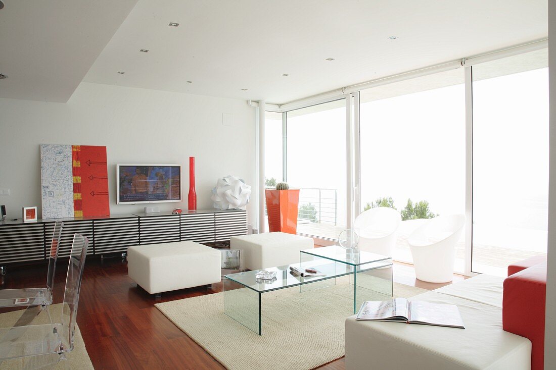 Designer-Wohnraum mit Möbeln aus Acrylglas und Farbakzenten in Orange