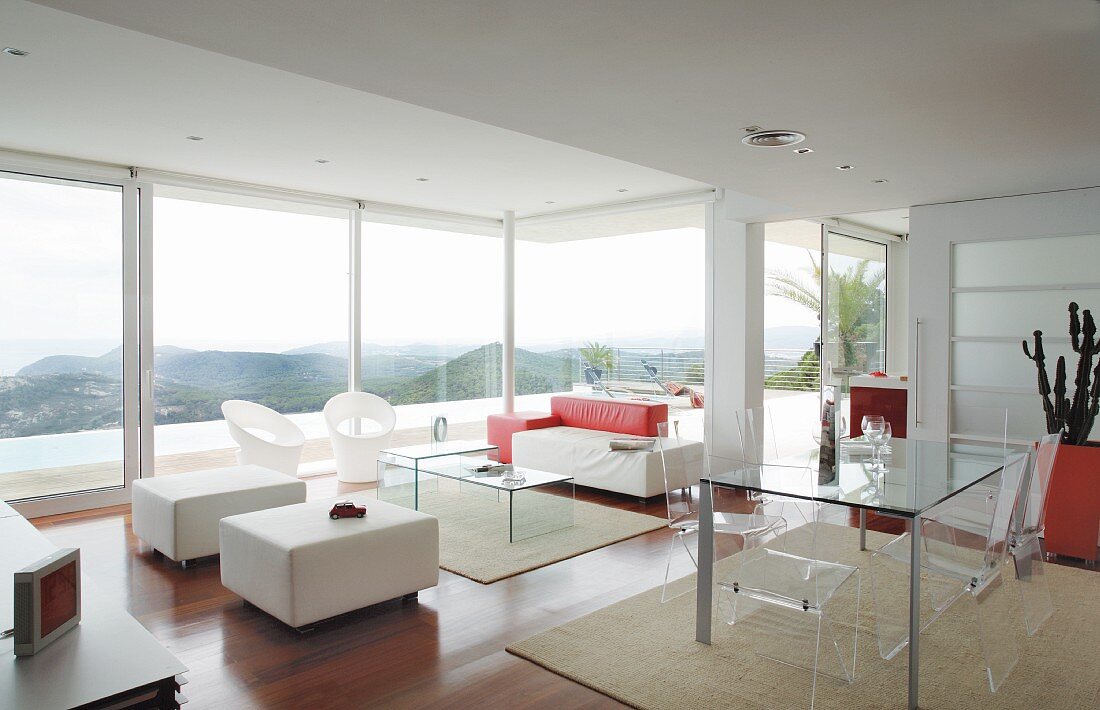 Designer interior with plexiglas furniture and view of landscape through glass wall