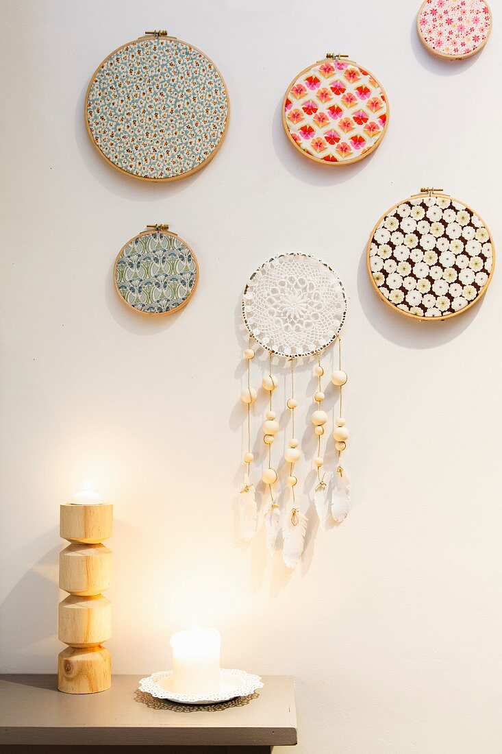 Embroidery frames covered in colourful fabrics and hand-crafted dreamcatcher hung on wall