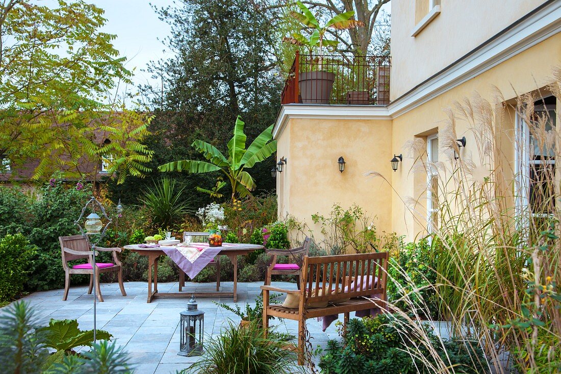 Terrasse mit Gartenmöbeln vor französischem Landhaus