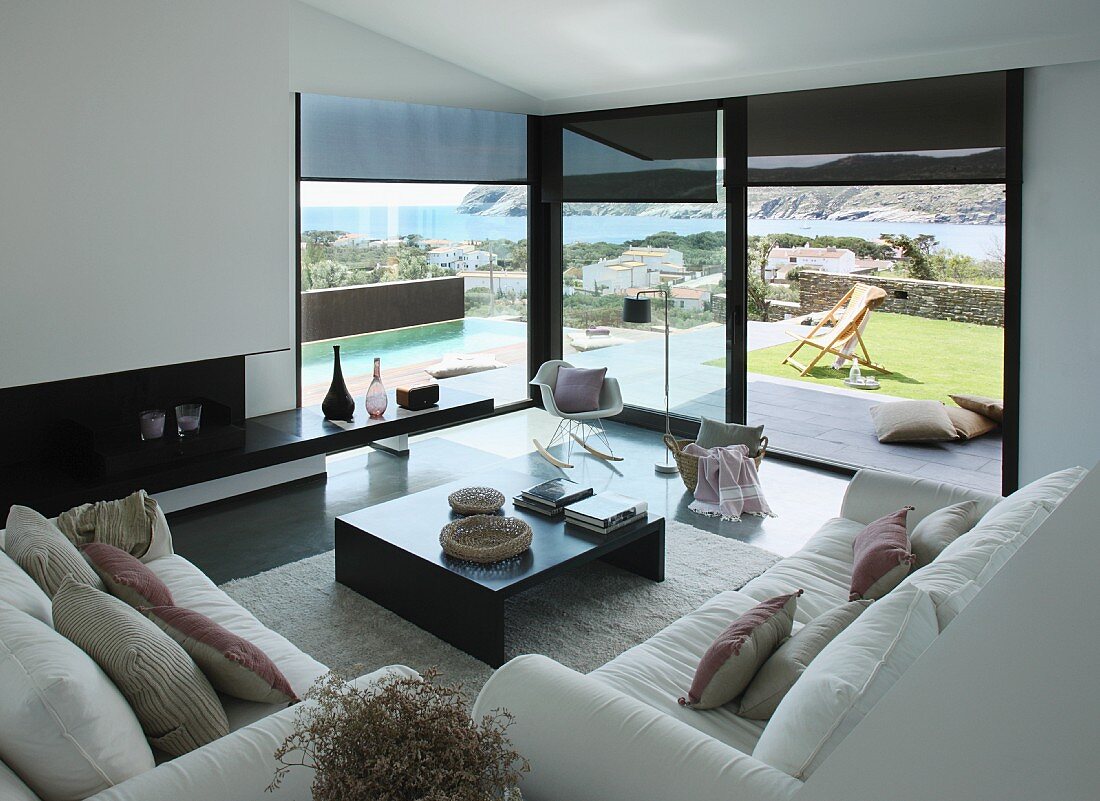 Blick auf Sofas mit Coffeetable und Klassiker Schaukelstuhl im Wohnzimmer mit Meerblick