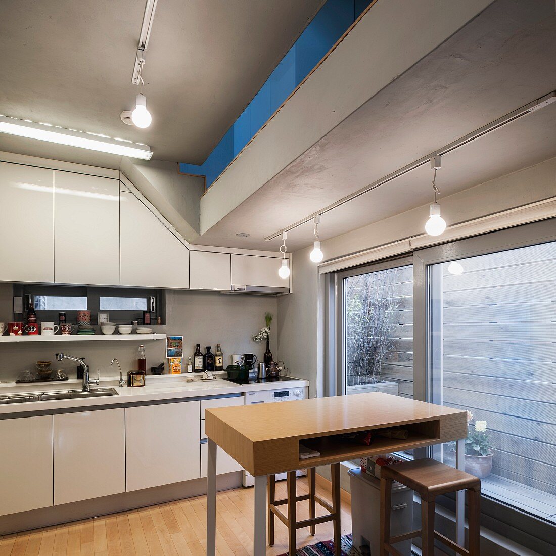 Einbauküche in südkoreanischem Haus; Schiebetür zu Freisitz mit Sichtschutzwand und Öffnungsschlitz zum Obergeschoss