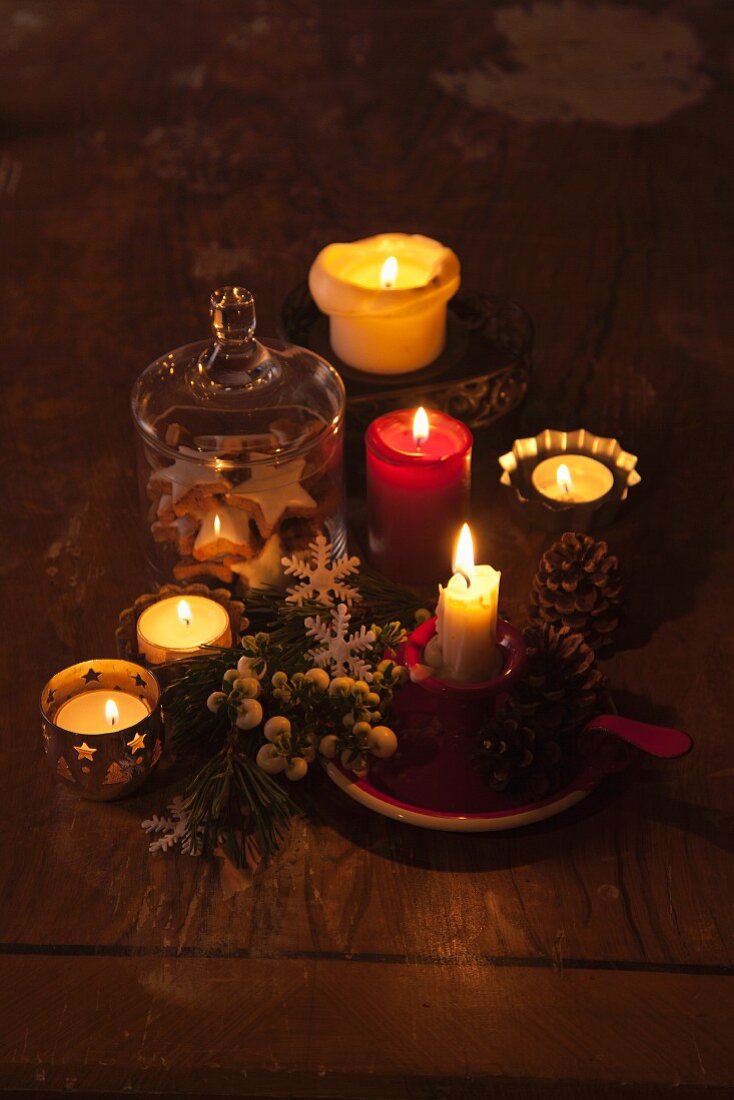 Dim light from lit candles and tealights of festive arrangement
