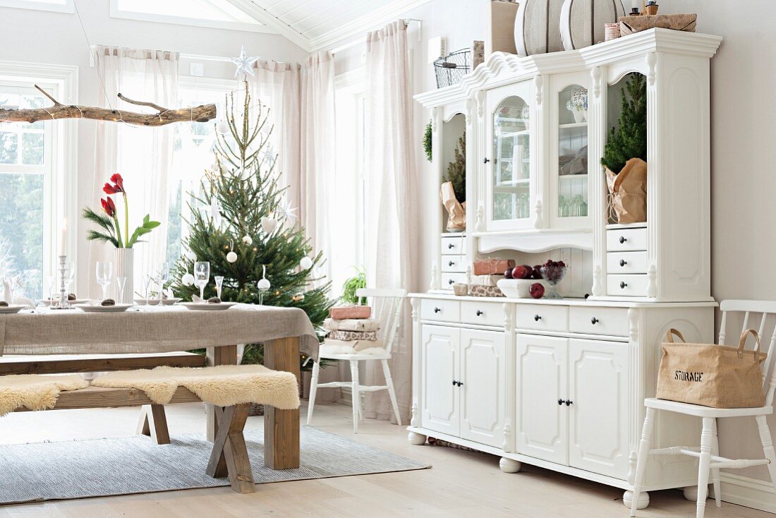 Gedeckter Weihnachtstisch mit Sitzbank und Geschirrschrank im Landhausstil