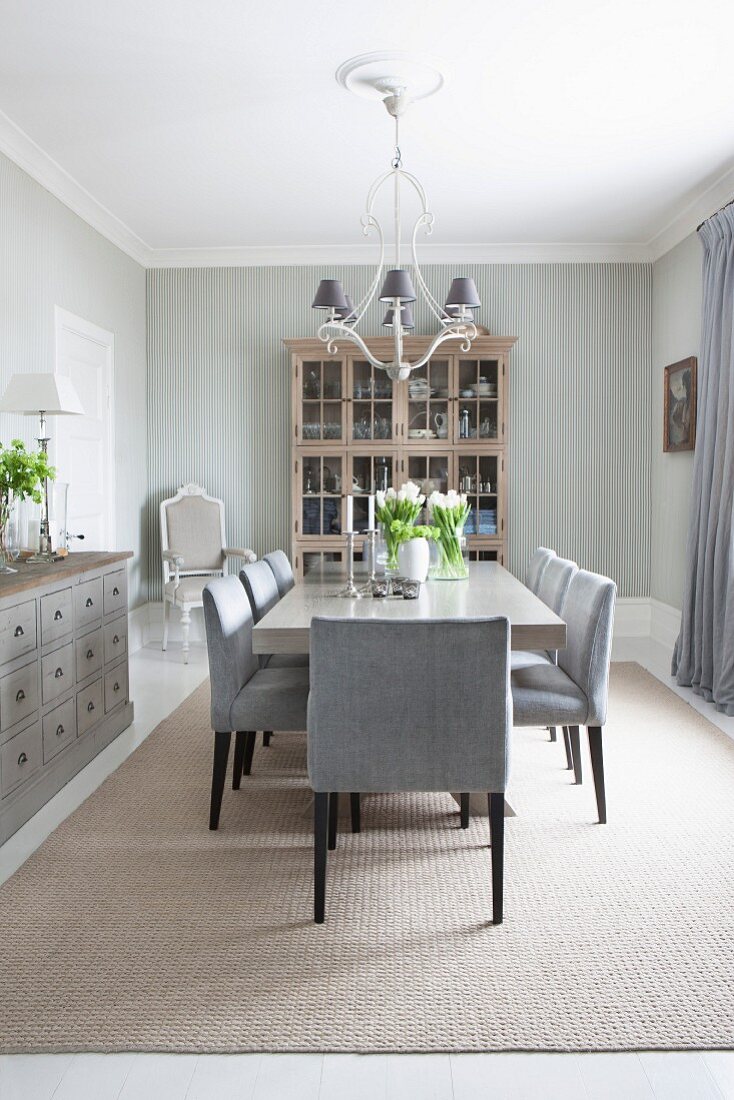Elegant dining room with glass-fronted cabinet, wood-clad walls and subtle shades of grey
