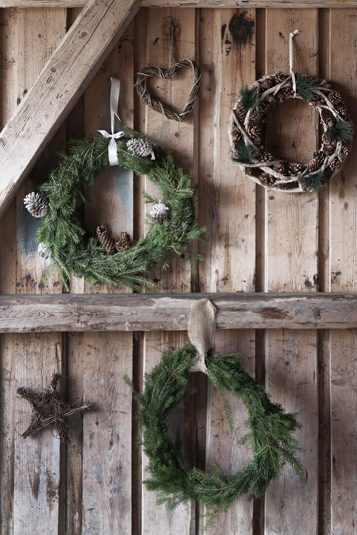 Various wreaths of for branches on rustic wooden wall