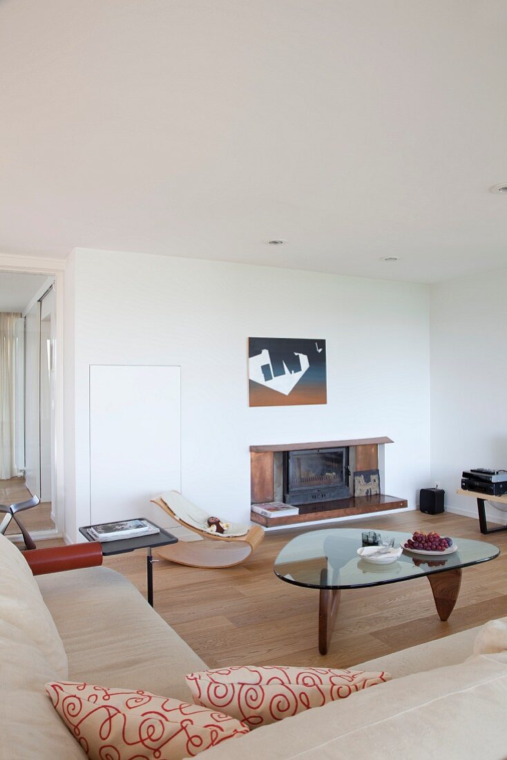 Corner sofa, glass table and fireplace in modern living room