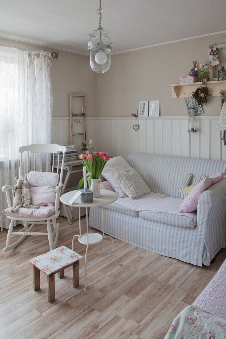 Rocking chair and sofa with striped pastel cover in Scandinavian country-house style