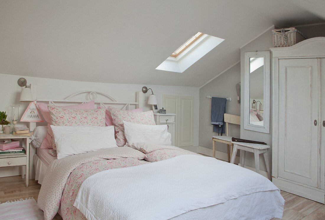 Romantisches Doppelbett mit rosa Bettwäsche im Shabby Dachgeschosszimmer