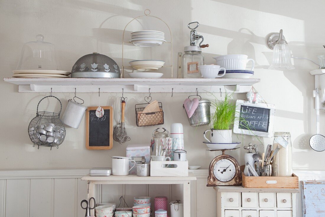 Shelf with cup hooks, small chest of drawers and open shelves of various nostalgic kitchen implements