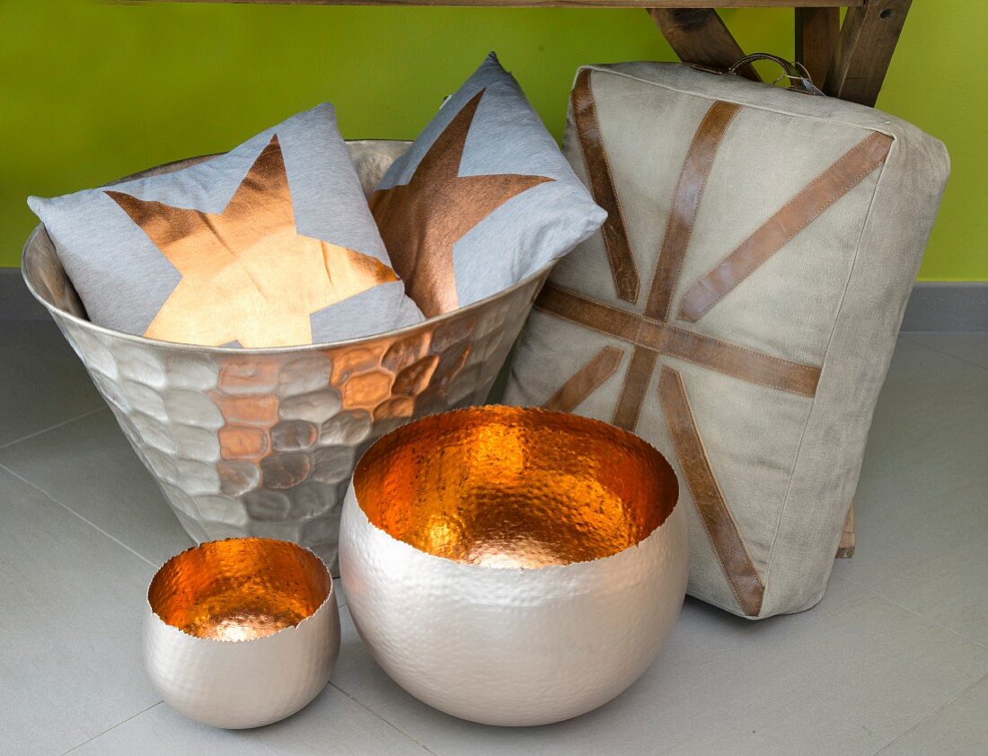 Bowls with copper-coloured interiors, cushions in metal bowl and linen seat cushion