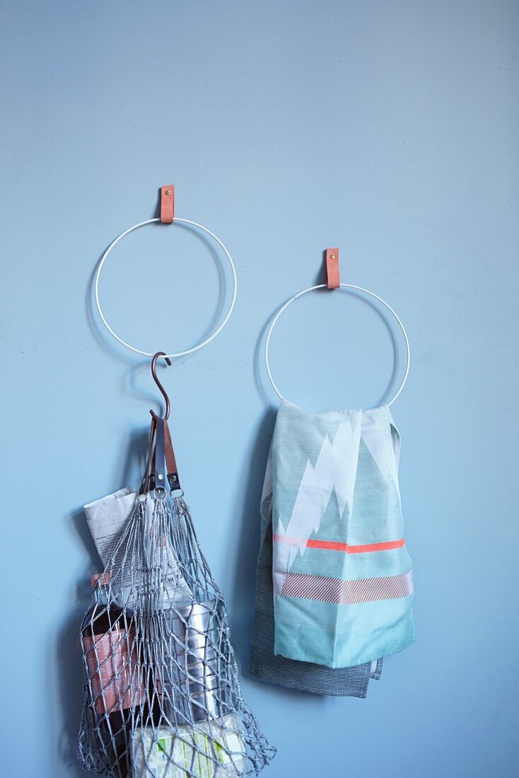 Selbst gebastelte Handtuchhalter mit Lederlaschen an blauer Wand aufgehängt