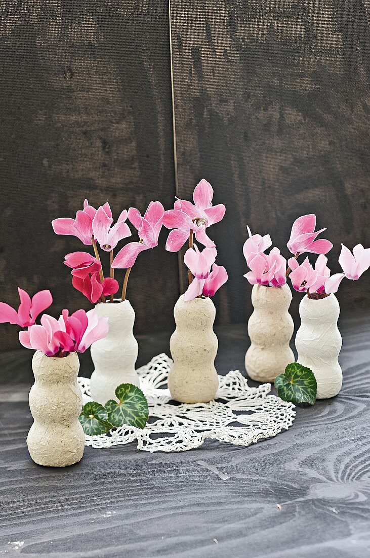 Pink cyclamen in handmade papier mâché vases