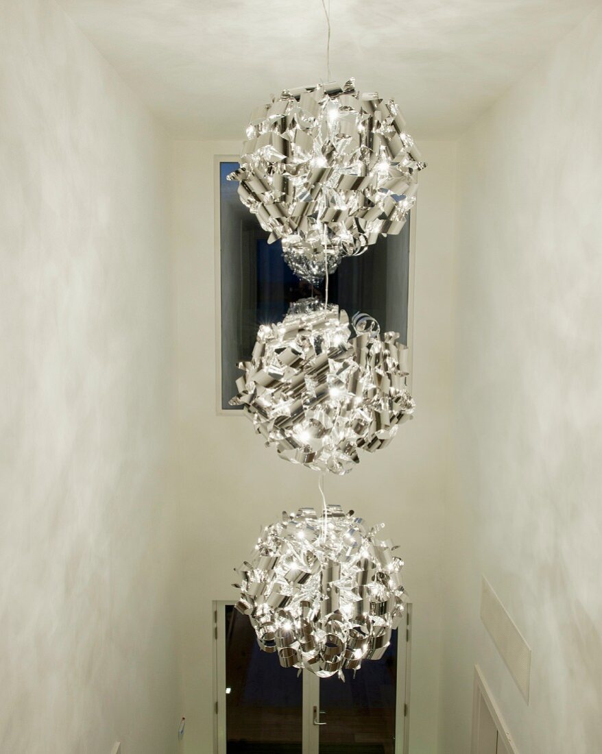 Three-part modern pendant lamp in tall hallway