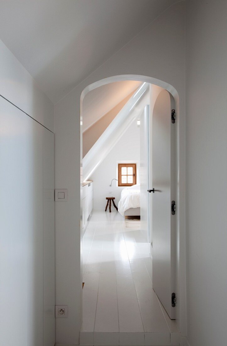 View into renovated, white-painted attic room with lattice window